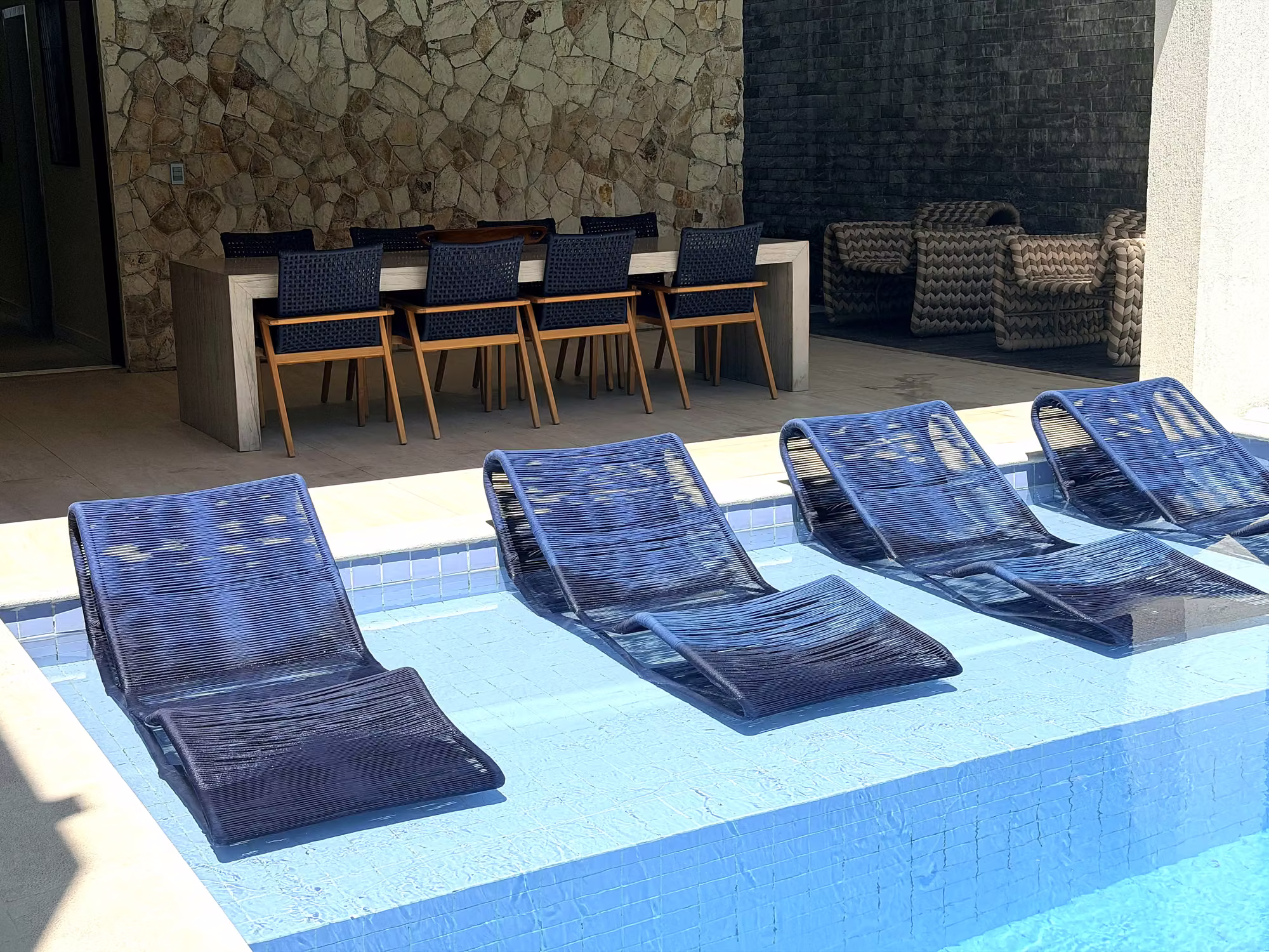 Deck com espreguiçadeiras dentro da piscina
